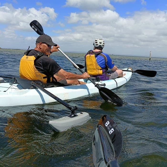 A support worker and participant kayaking together on the water