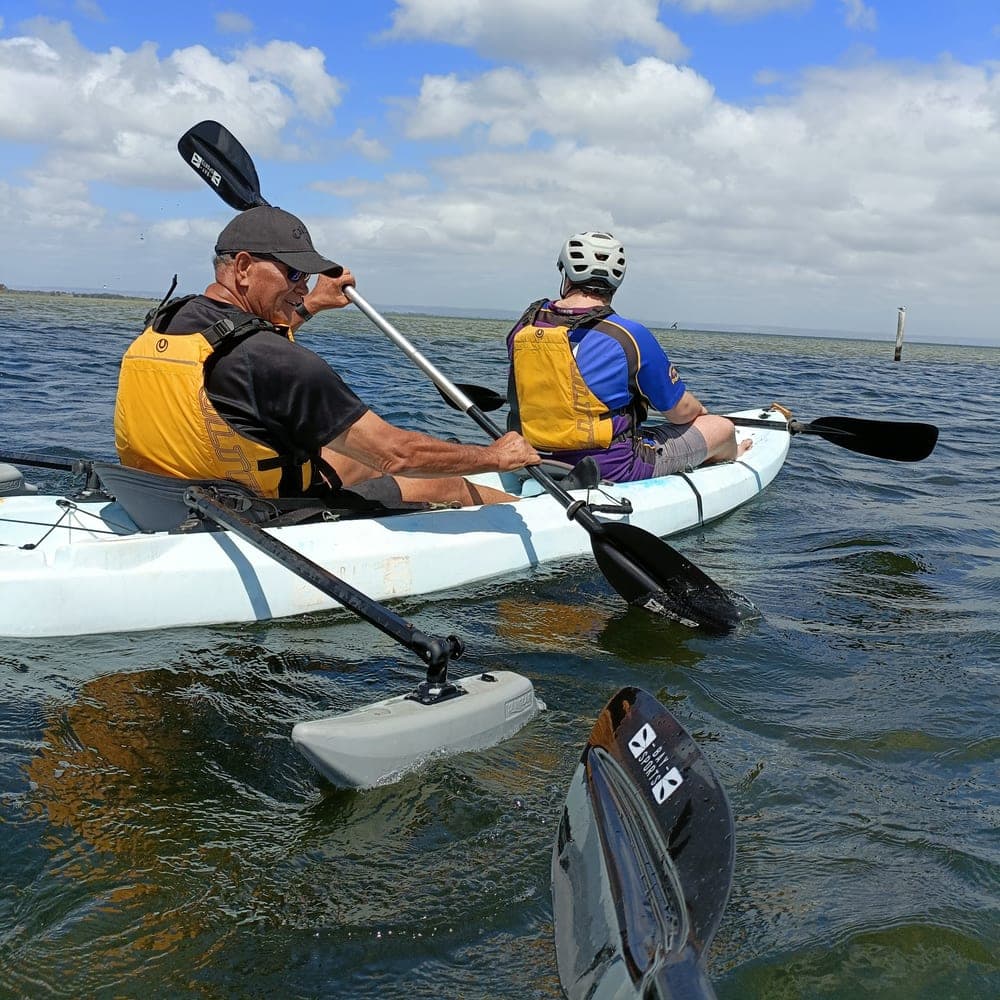 A Meridian support worker and participant kayaking together on a bright Perth waterway